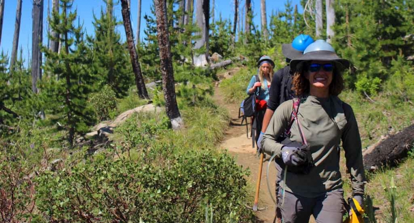 a group of people walk along a trail during a service project 